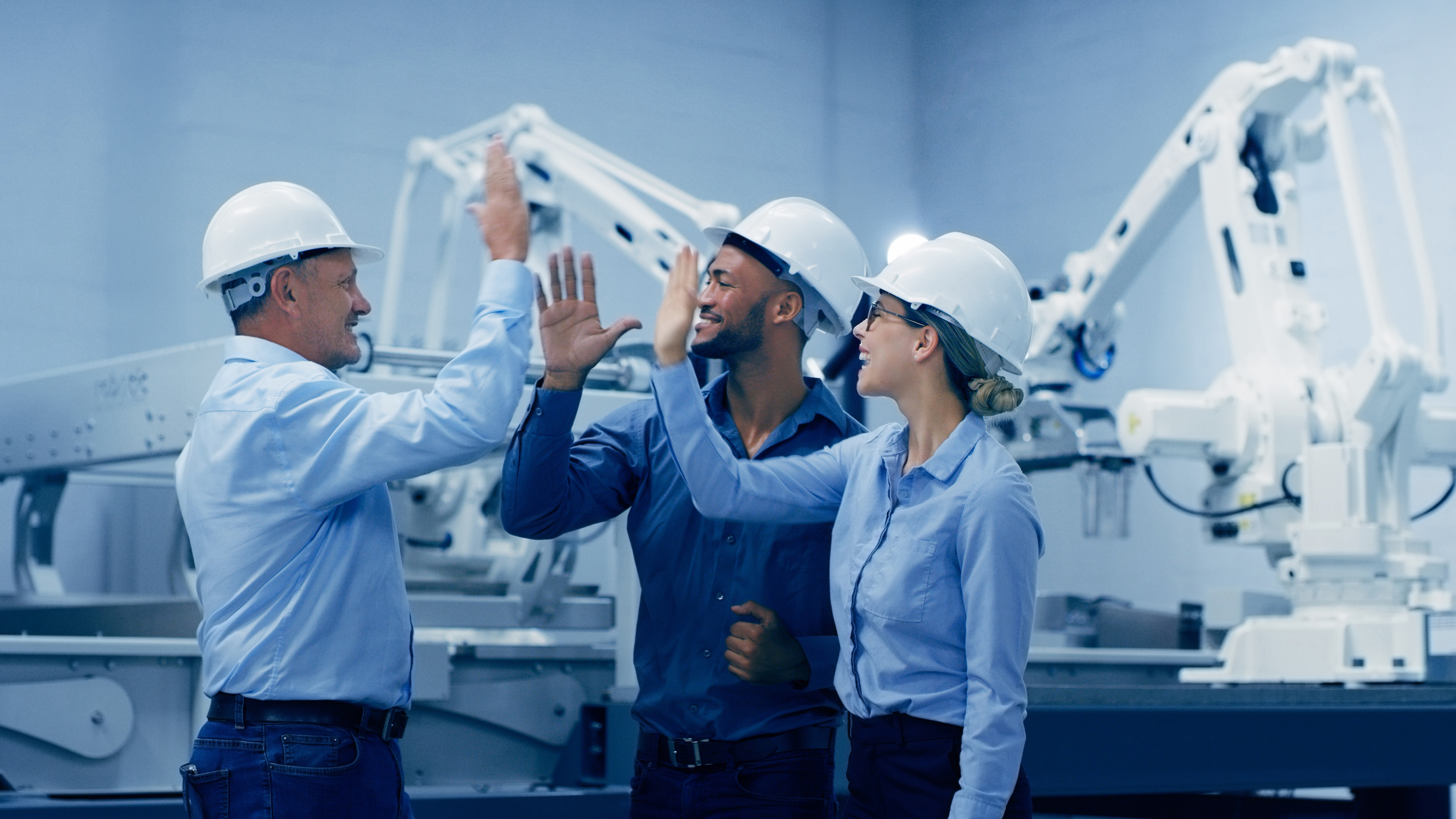 A team of smart manufacturing workers celebrating after completing a project